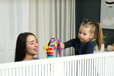 Mother and daughter performing puppet show at home