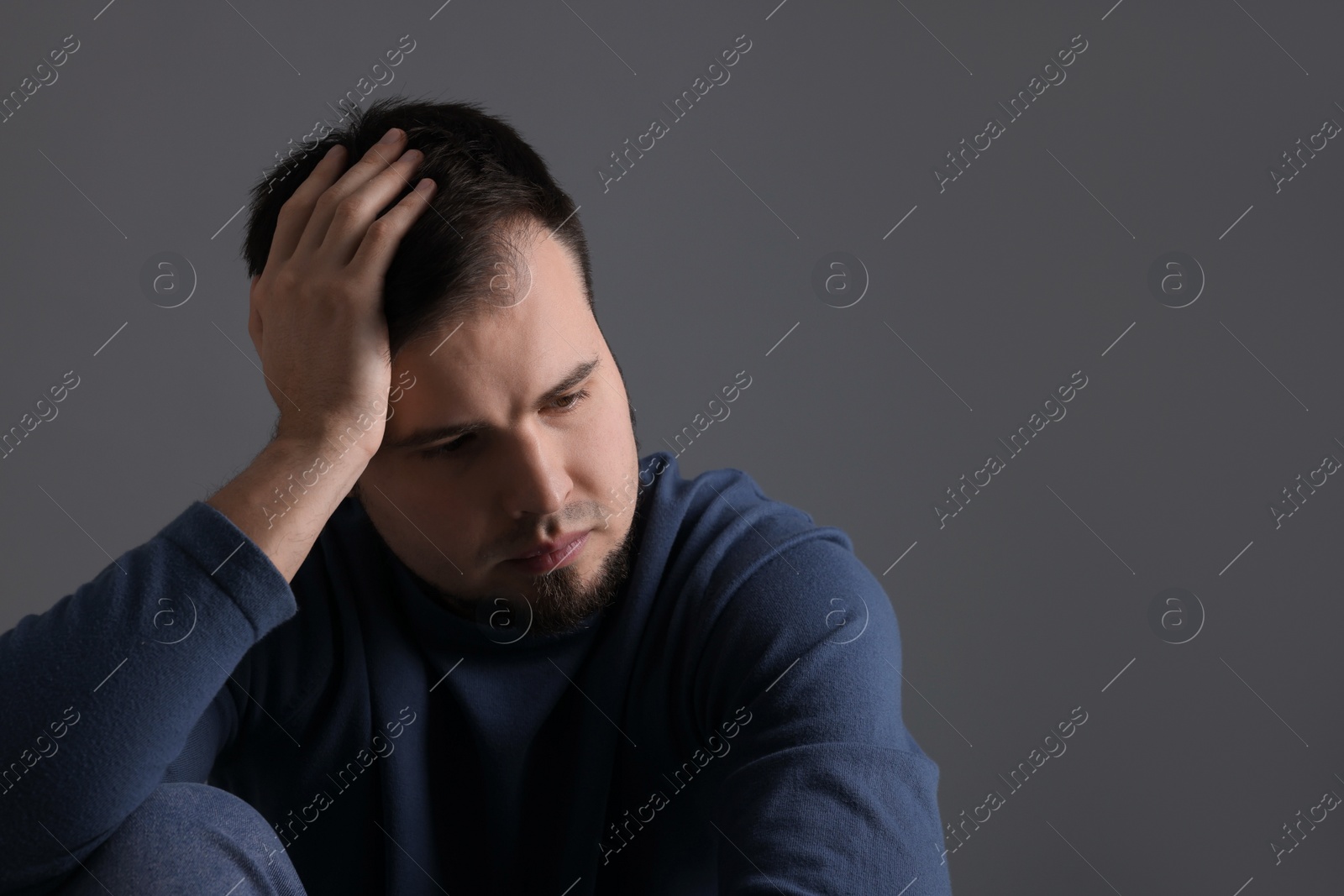 Photo of Portrait of sad man on dark grey background