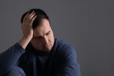 Photo of Portrait of sad man on dark grey background