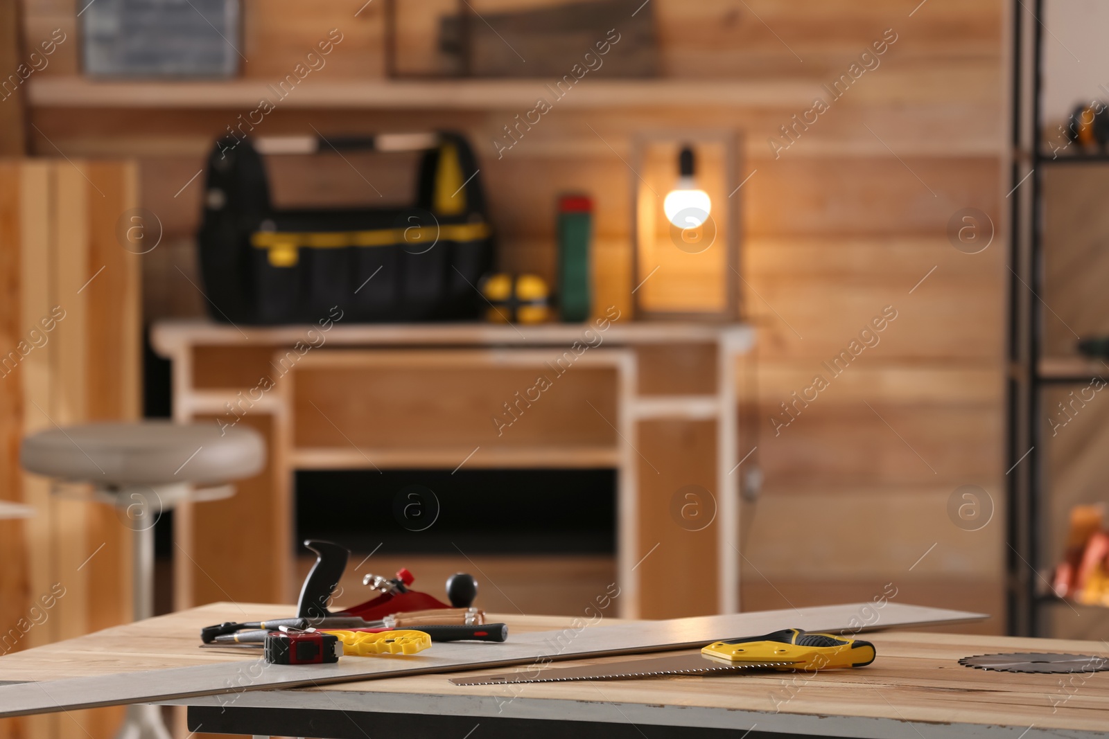 Photo of Different carpenter's tools on wooden table in workshop. Space for text