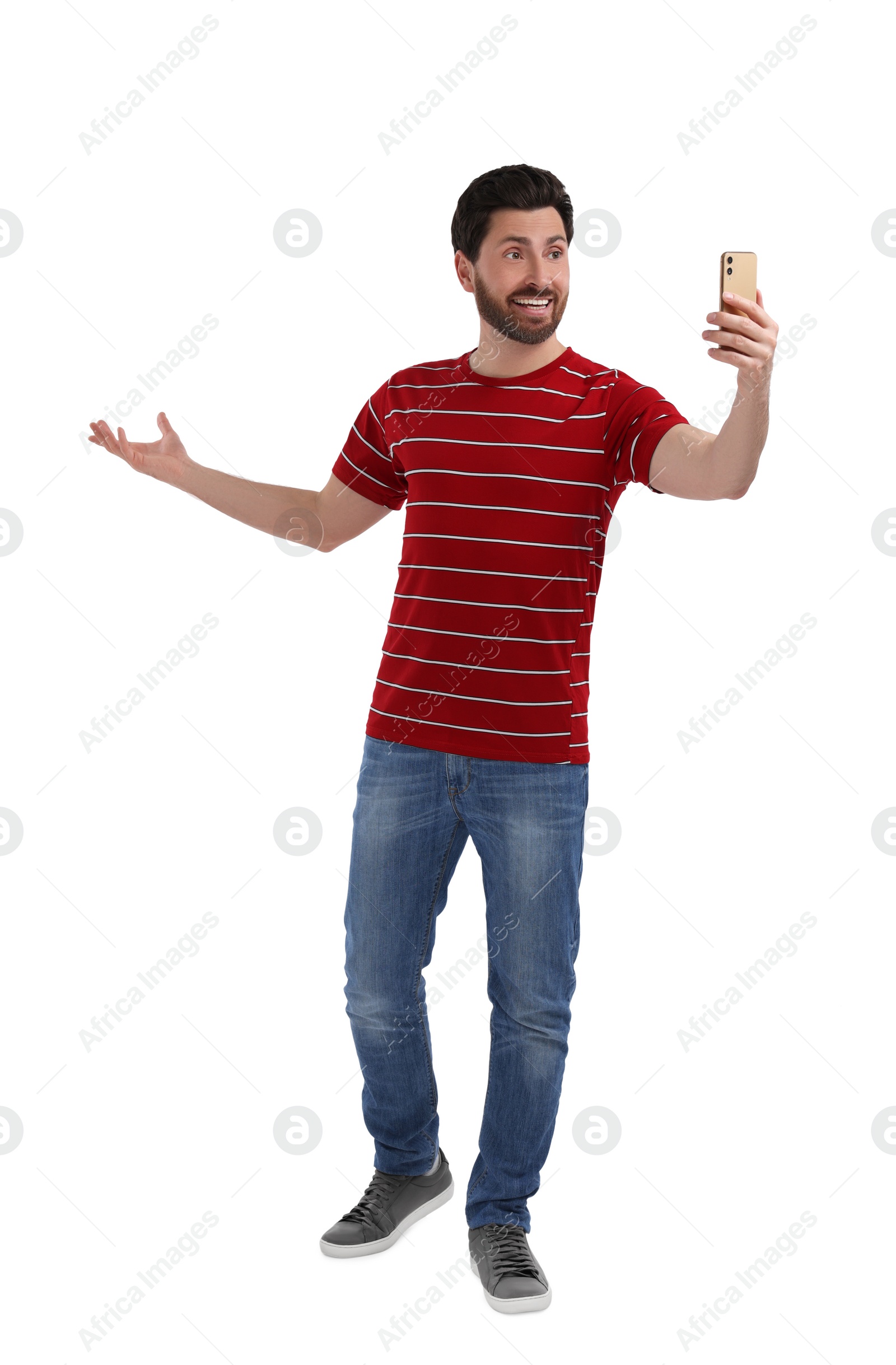 Photo of Smiling man taking selfie with smartphone on white background