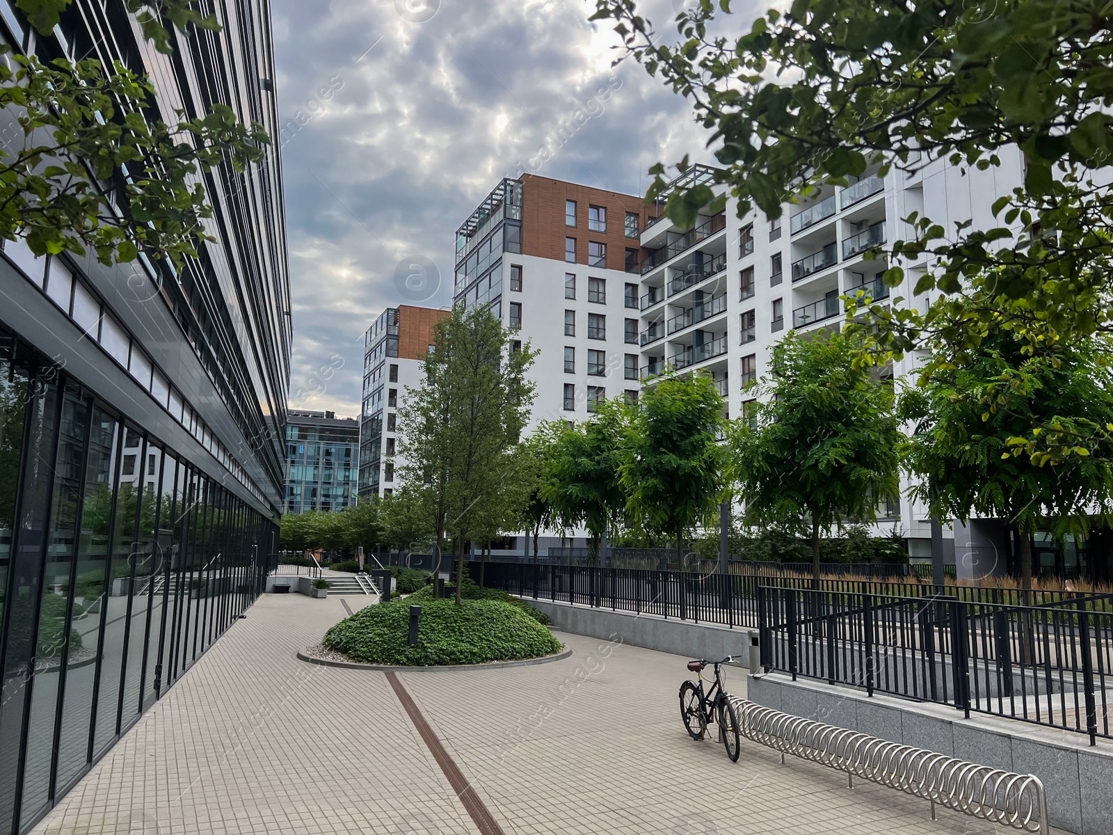 Photo of Beautiful view of modern buildings and green trees in city