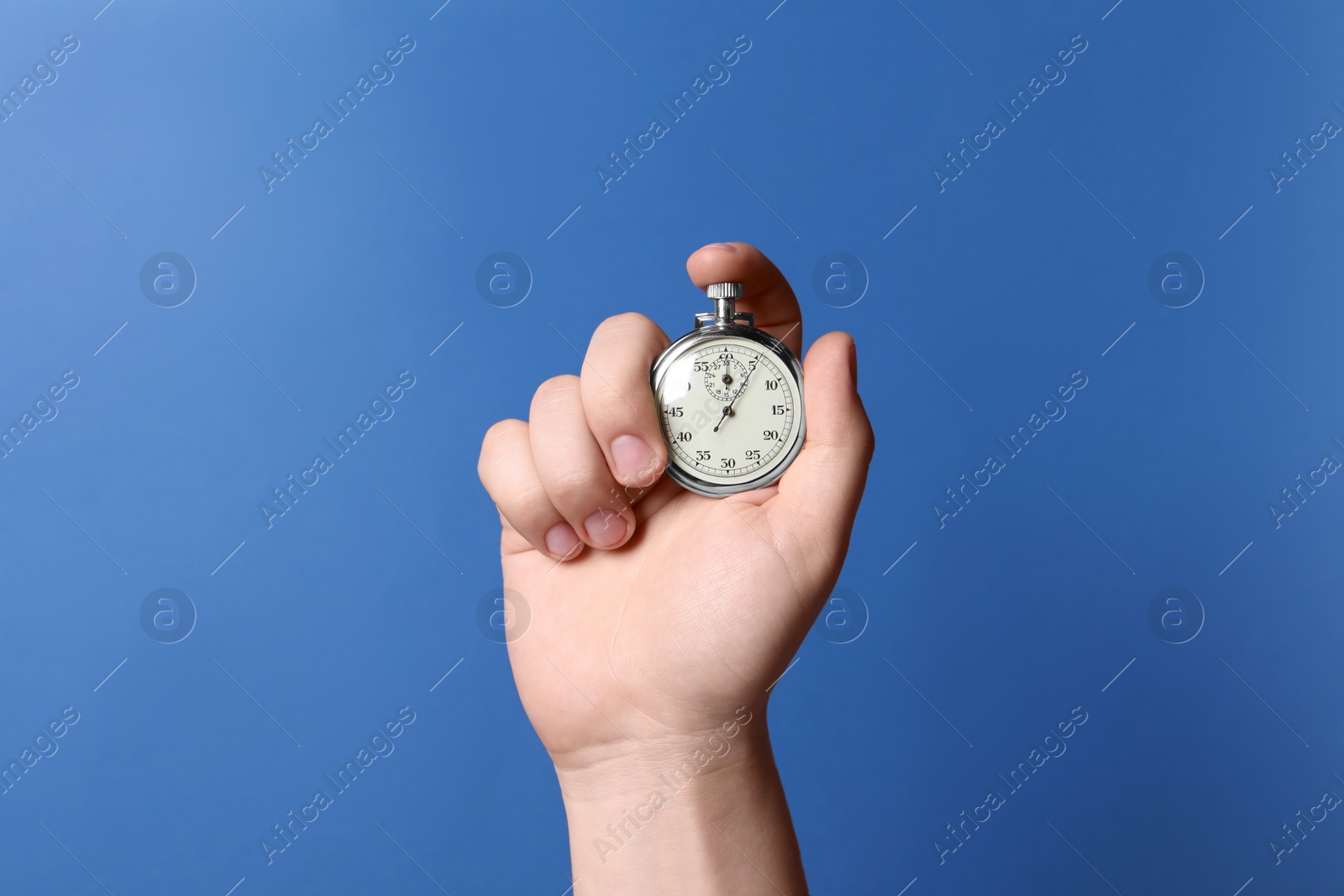 Photo of Man holding vintage timer on blue background, closeup