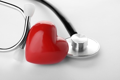 Stethoscope with heart on white background, closeup