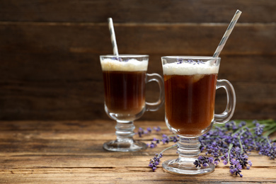 Photo of Delicious coffee with lavender on wooden table