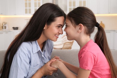 Photo of Happy mother and daughter touching foreheads at home. Single parenting
