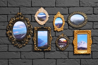 Photo of Vintage frames with photos of beautiful landscapes hanging on dark brick wall
