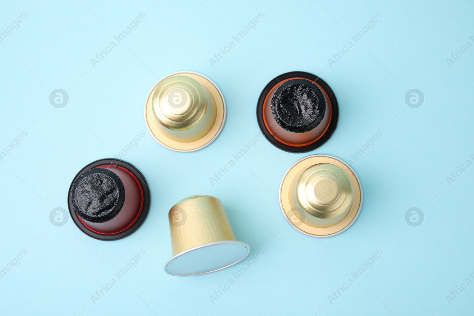 Photo of Many coffee capsules on light blue background, flat lay