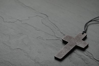 Photo of Christian cross on black table, space for text