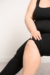 Photo of Overweight woman on light background, closeup of legs