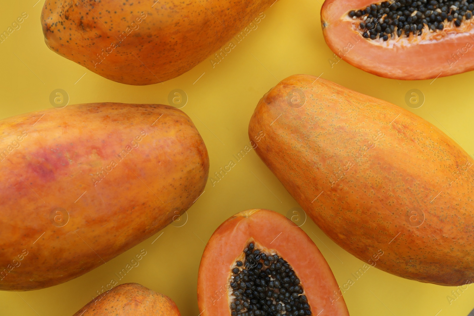 Photo of Fresh ripe cut and whole papaya fruits on light green background, flat lay