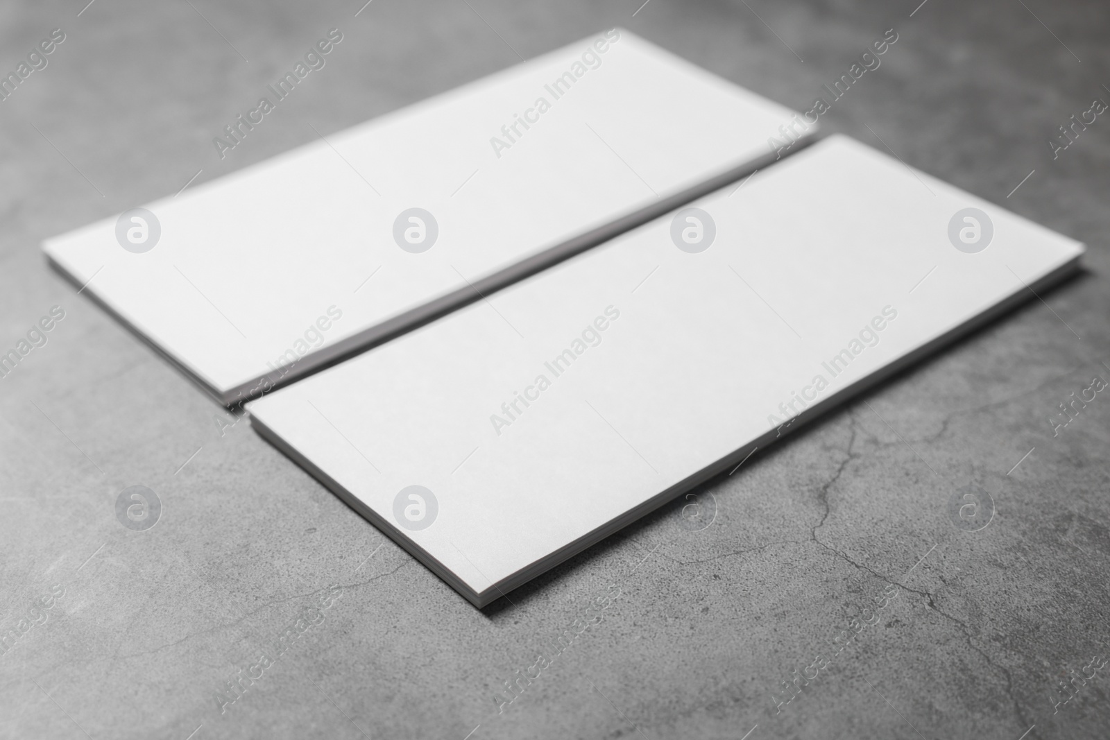 Photo of Blank business cards on grey textured table, closeup. Mockup for design