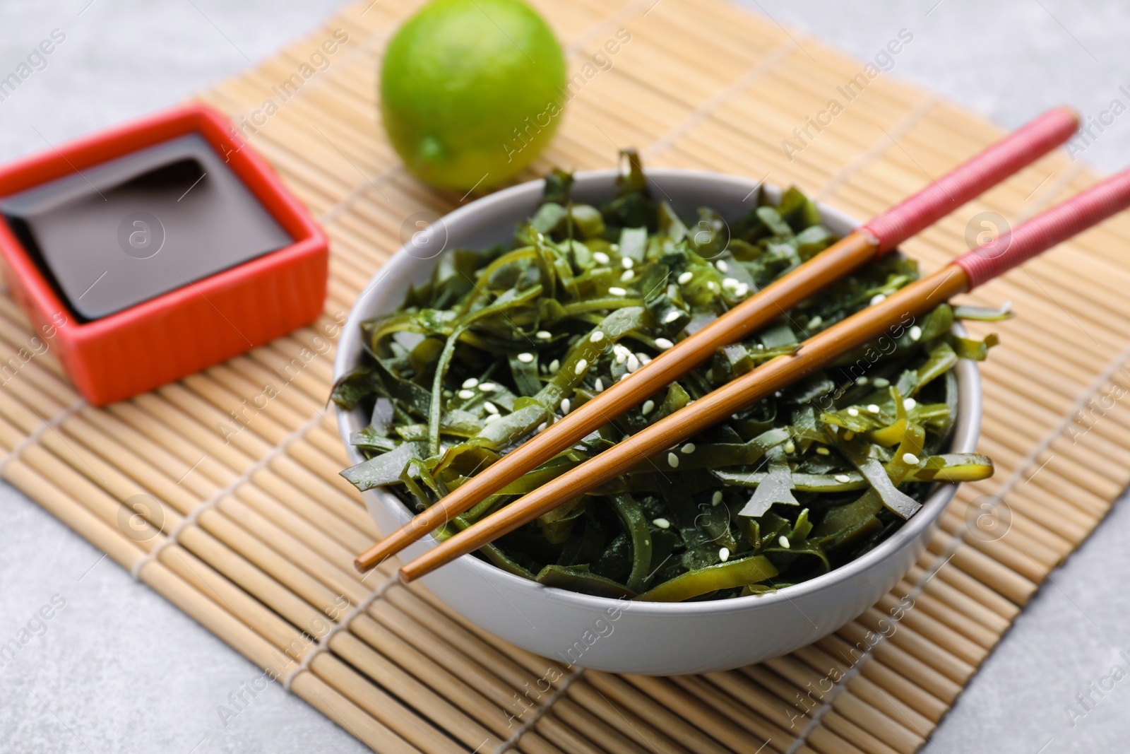 Photo of Fresh laminaria (kelp) seaweed served on light gray table