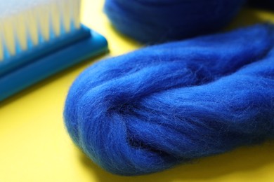 Photo of Blue felting wool on yellow background, closeup