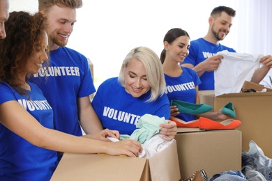 Team of volunteers collecting donations in boxes indoors