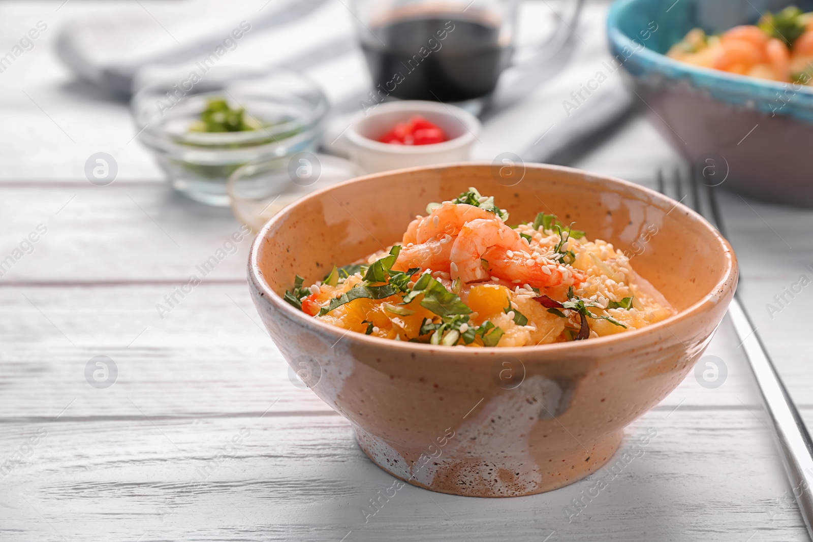 Photo of Bowl with tasty shrimps and grits on table