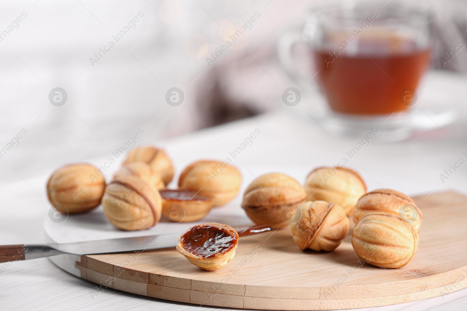 Photo of Homemade walnut shaped cookies with boiled condensed milk on white table indoors, space for text. Bokeh effect