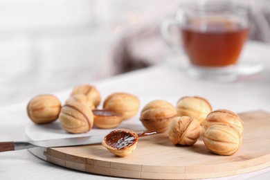 Photo of Homemade walnut shaped cookies with boiled condensed milk on white table indoors, space for text. Bokeh effect