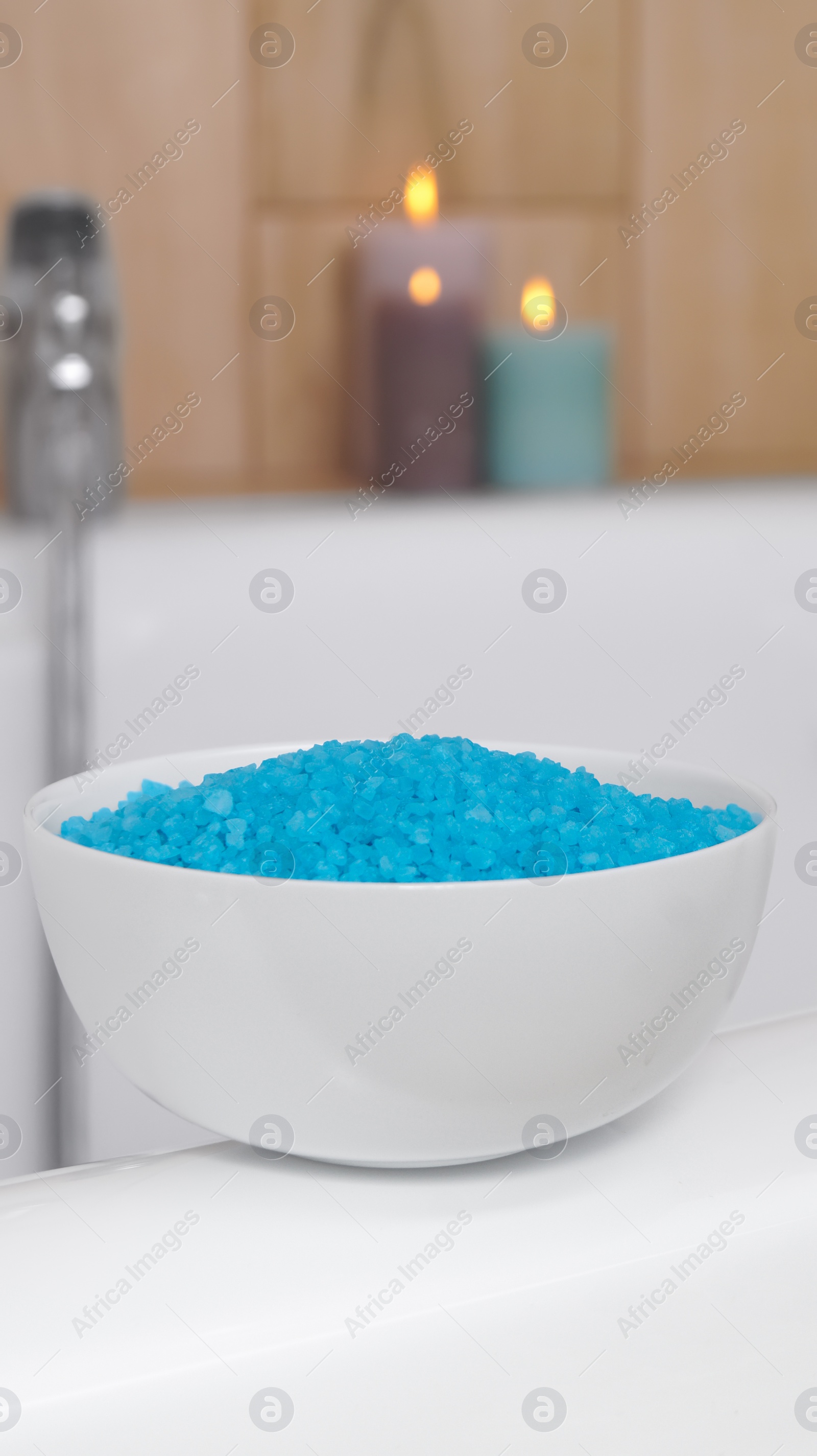 Bowl with sea salt on white bath Photo of Bowl with sea salt on white bath
