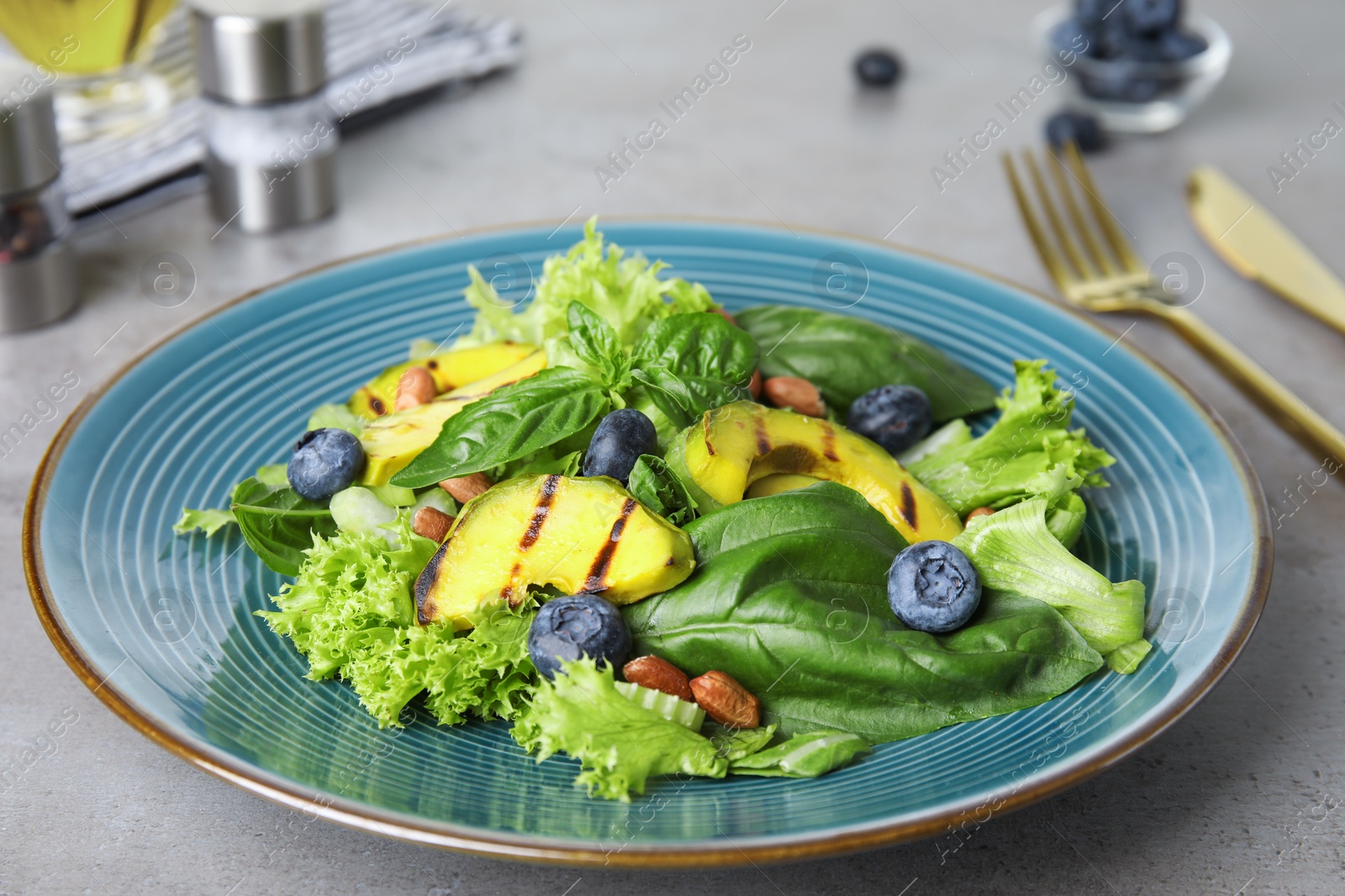 Photo of Delicious avocado salad with blueberries on grey table