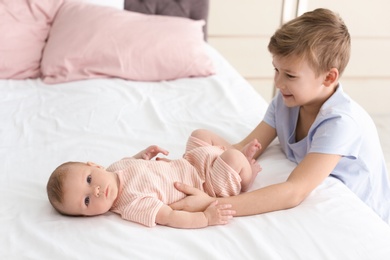 Photo of Cute boy playing with little baby at home