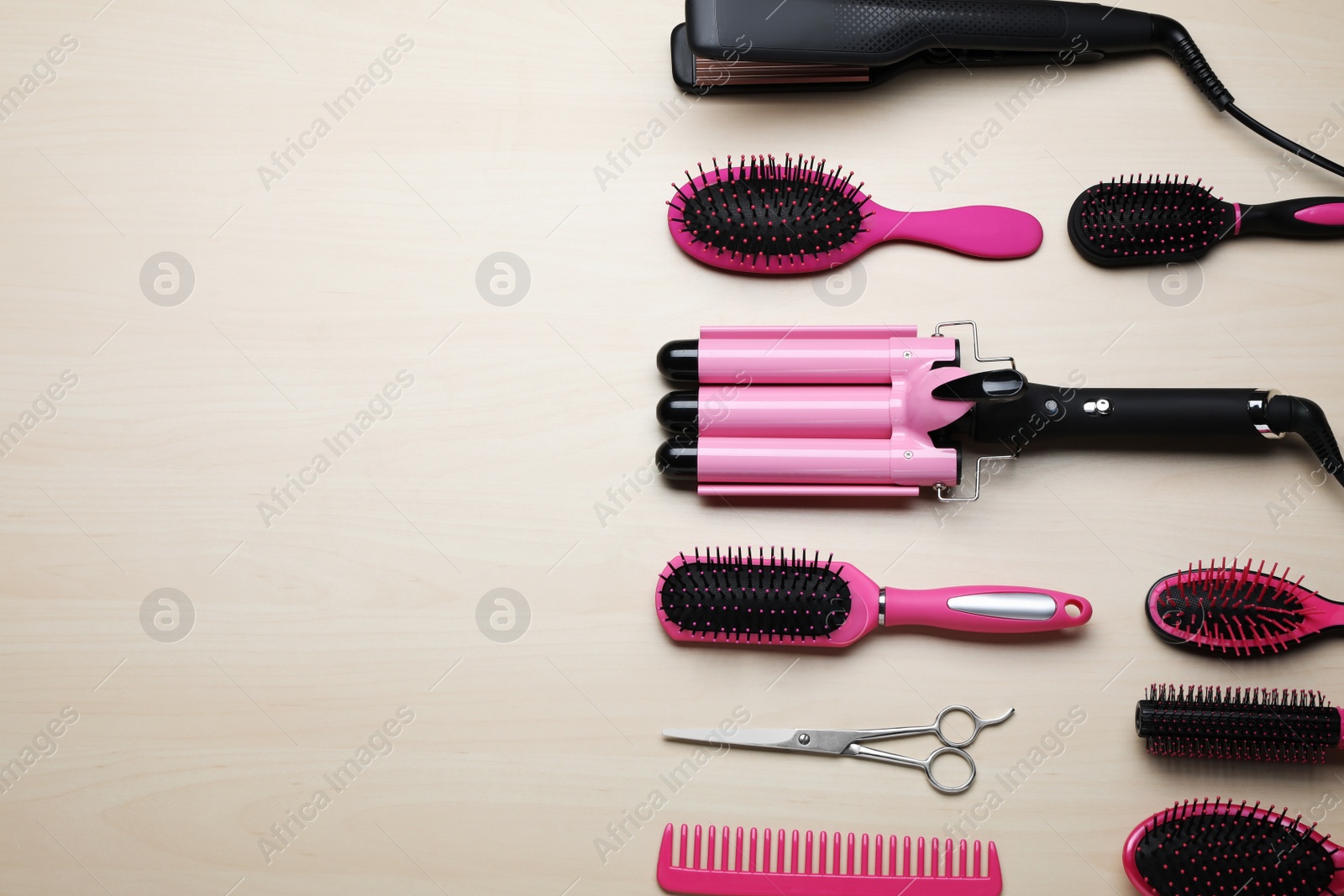 Photo of Flat lay composition of professional hairdresser tools on beige table, space for text