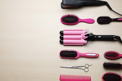 Flat lay composition of professional hairdresser tools on beige table, space for text