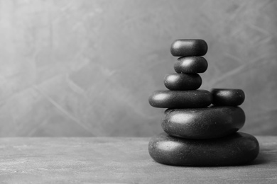 Photo of Stack of zen stones on table against grey background. Space for text