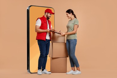 Image of Courier delivering parcels to woman near huge smartphone on dark beige background