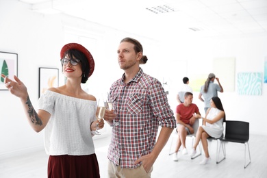 Young couple at exhibition in art gallery