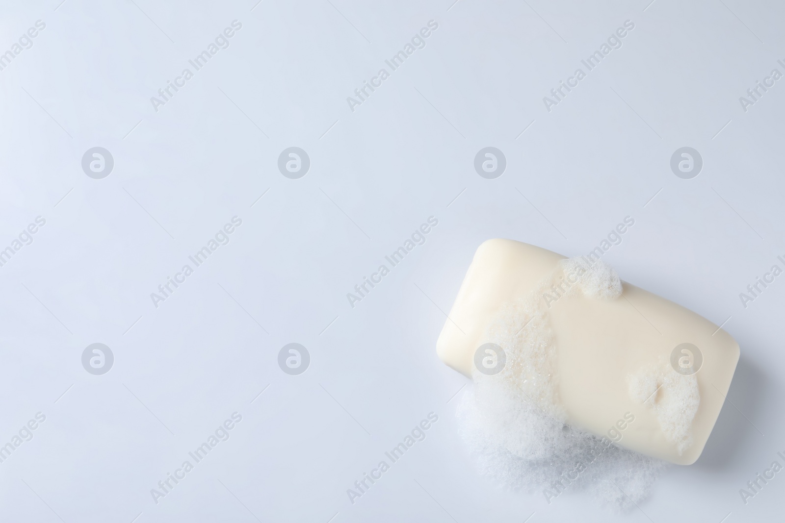 Photo of Soap with fluffy foam on white background, top view