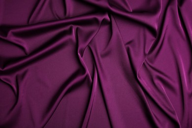 Crumpled purple silk fabric as background, top view