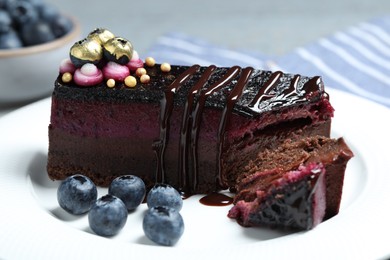 Photo of Delicious cake with blueberry on white plate, closeup