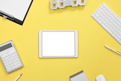 Photo of Modern tablet, keyboard and stationery on yellow background, flat lay. Space for text