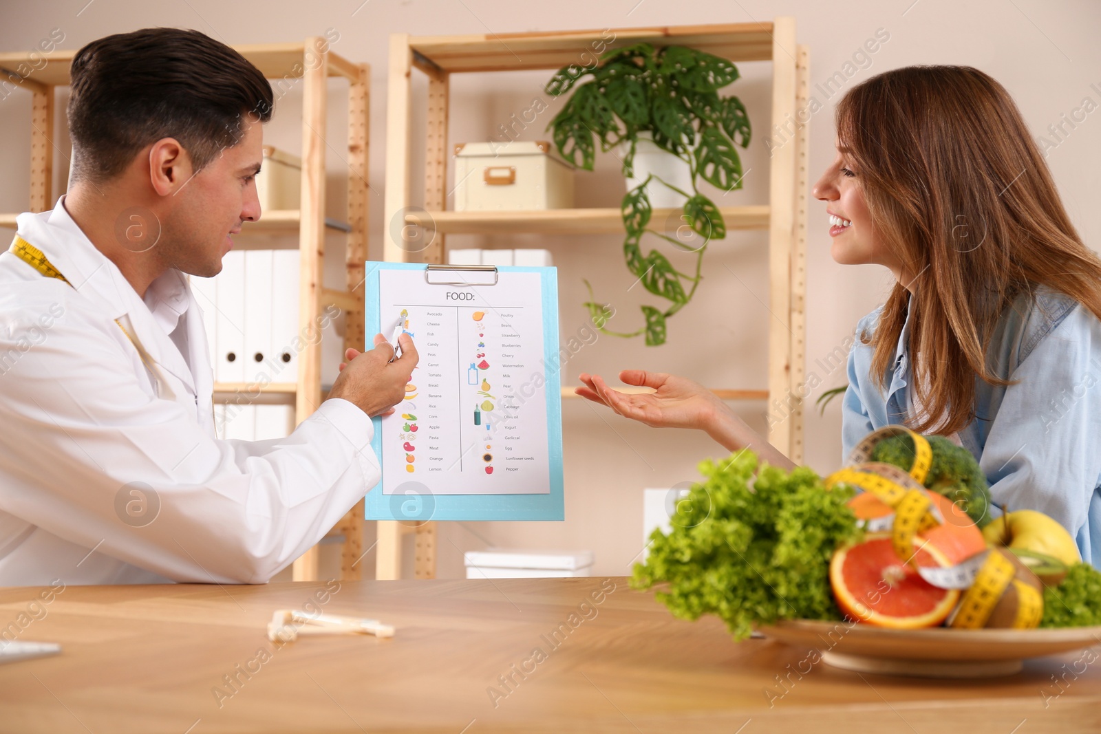 Photo of Nutritionist consulting patient at table in clinic