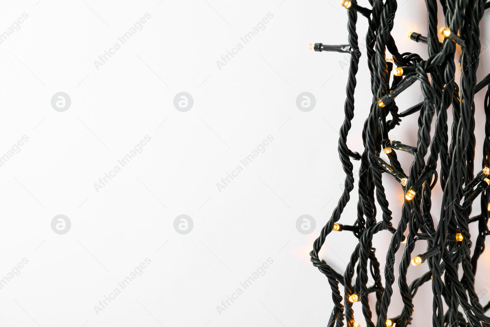 Photo of Beautiful Christmas lights on white background, top view