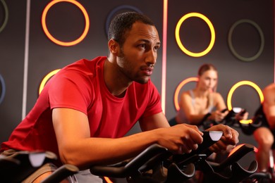 Photo of Group of people training on exercise bikes in fitness club