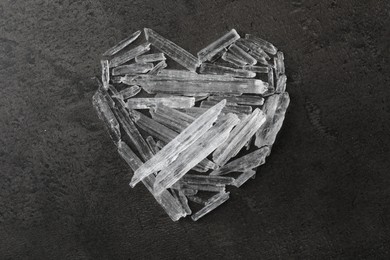 Photo of Menthol crystals in shape of heart on grey background, flat lay