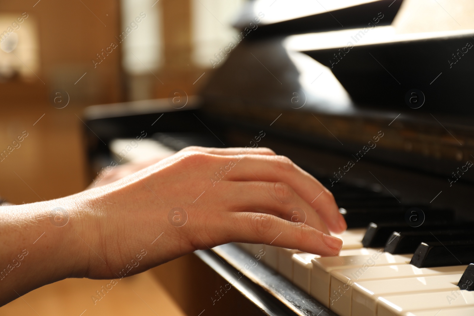 Photo of Young woman playing piano, closeup. Music lesson