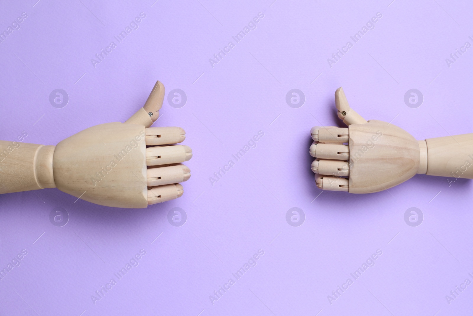 Photo of Wooden mannequin hands on lilac background, flat lay