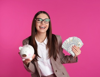 Businesswoman with money and piggy bank on color background