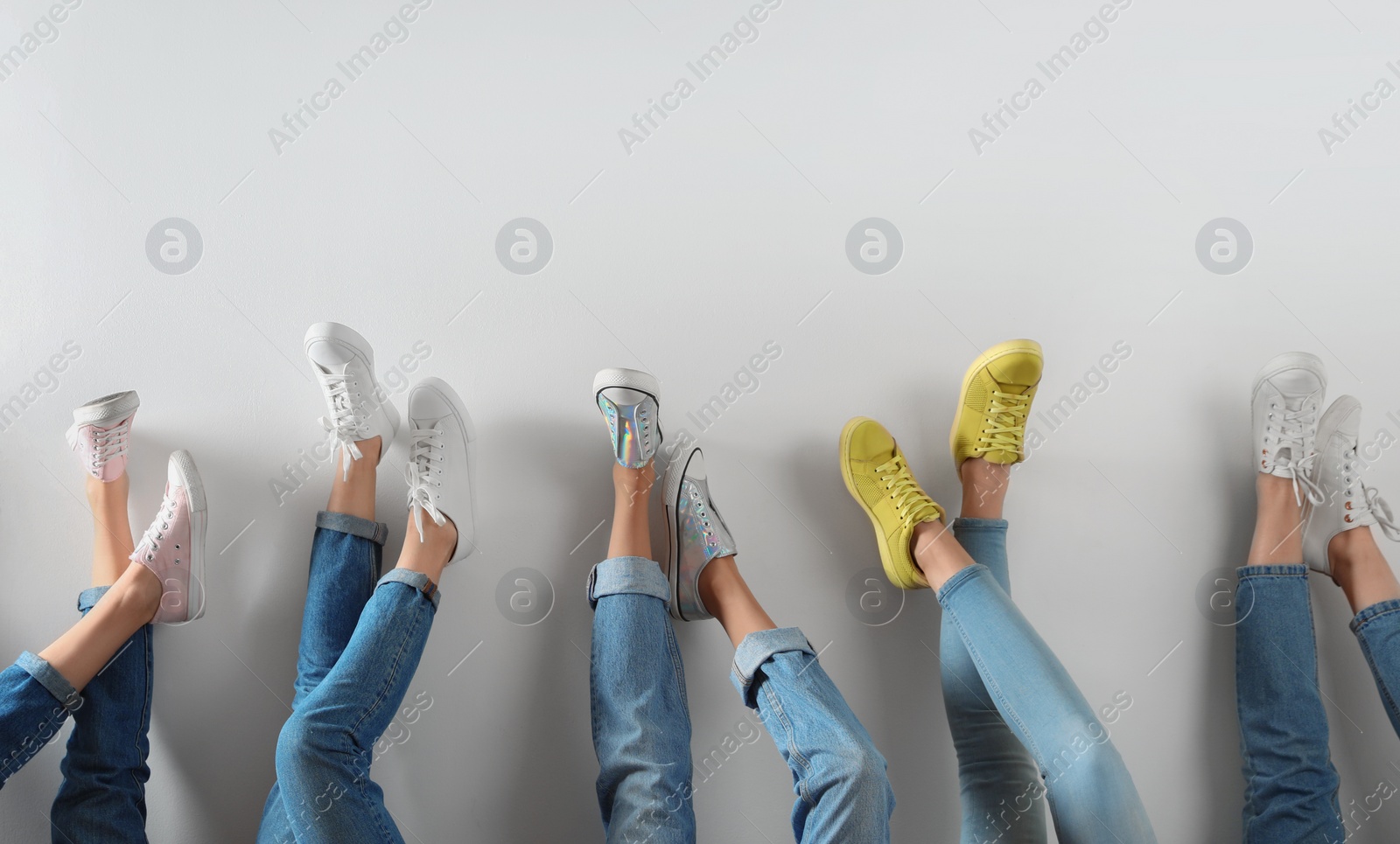 Photo of Young women in modern shoes on white background, closeup