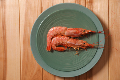 Photo of Fresh royal shrimps on wooden table, top view