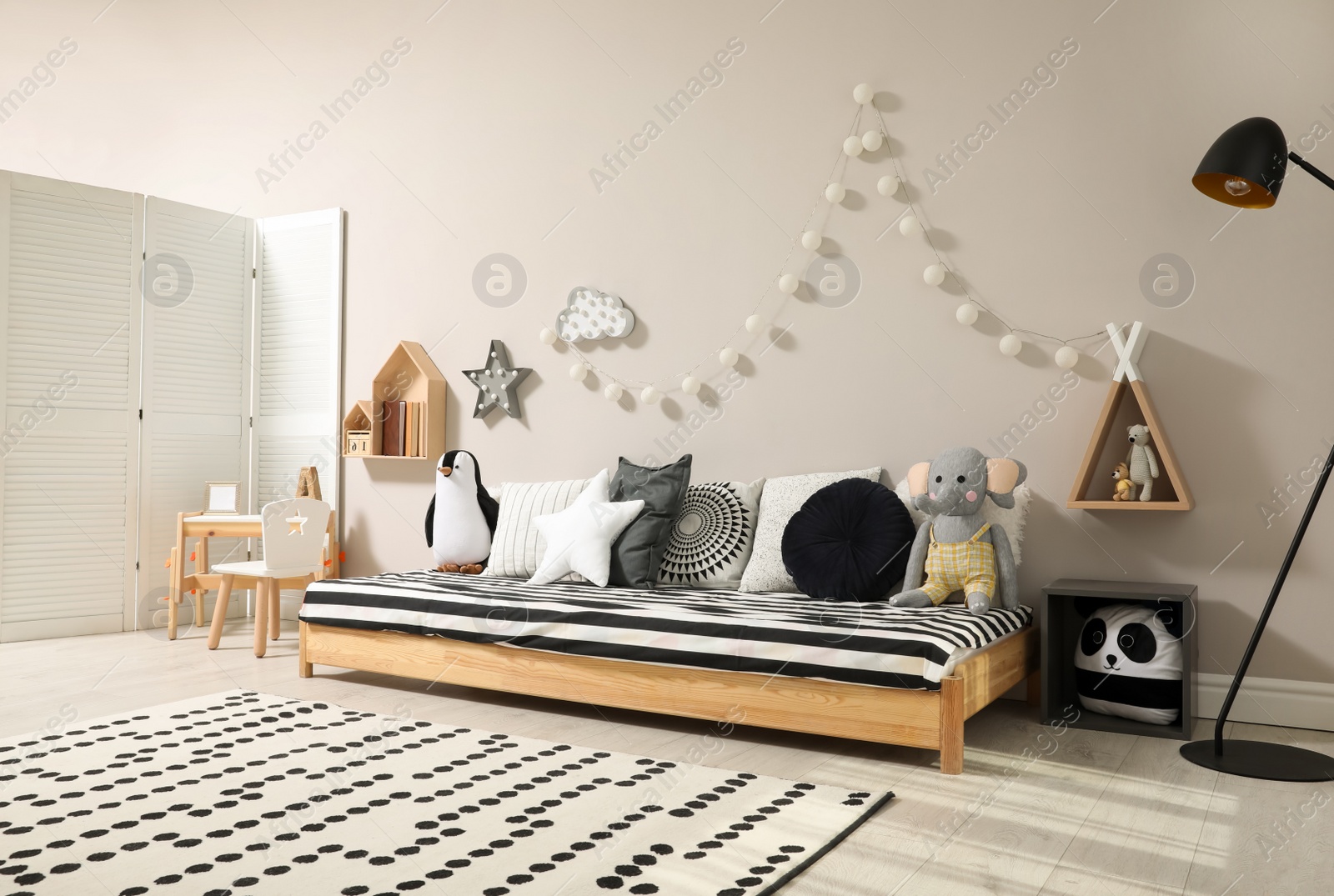 Photo of Cute kids room with stylish comfortable floor bed and toys. Montessori interior