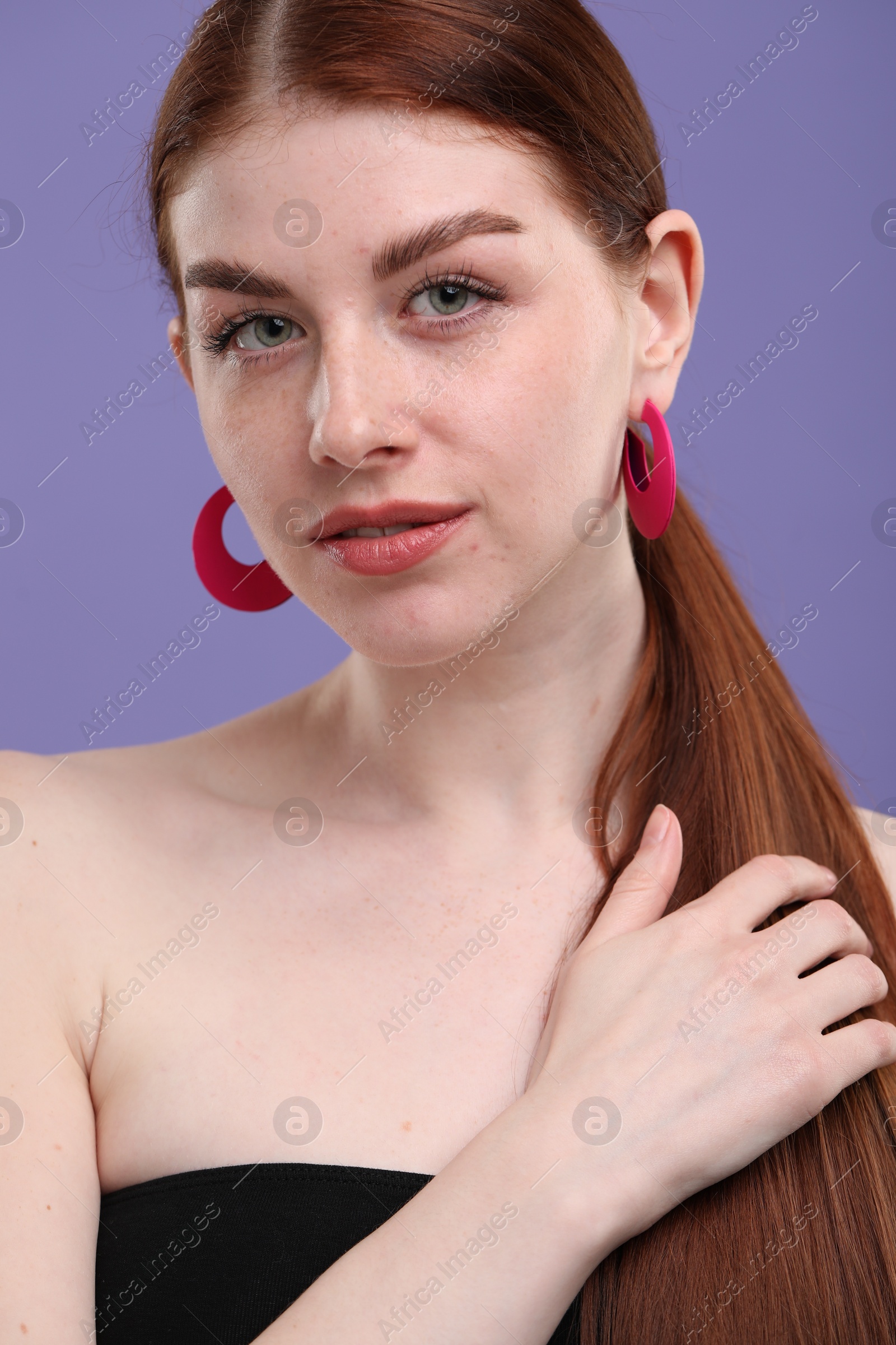 Photo of Portrait of beautiful woman with freckles on purple background, closeup