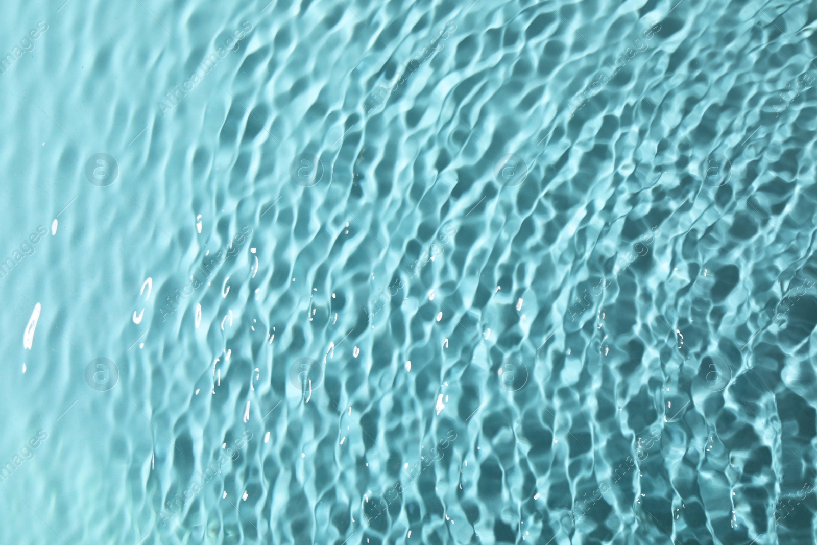 Photo of Closeup view of water with rippled surface on light blue background