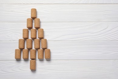 Christmas tree made of wine corks on white wooden table, top view. Space for text