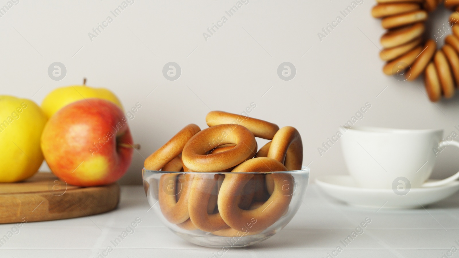 Photo of Bowl with delicious ring shaped Sushki (dry bagels) on white table