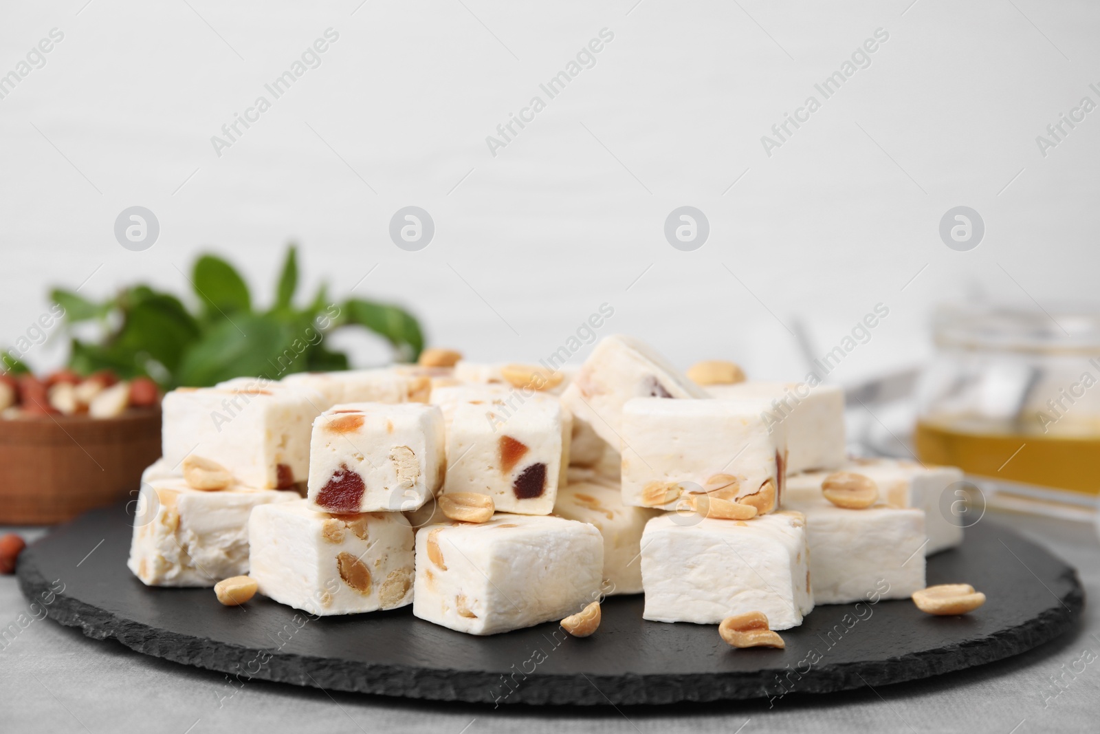 Photo of Pieces of delicious nutty nougat on black board