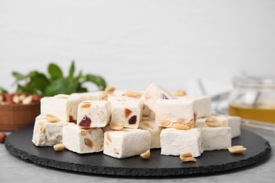 Photo of Pieces of delicious nutty nougat on black board